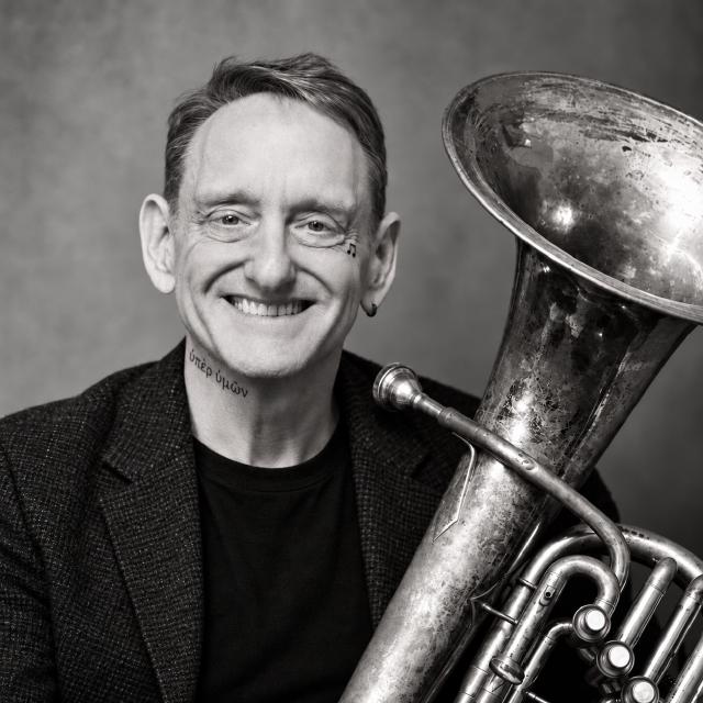 Black-and-white portrait of Larry Herzog Jr. holding his euphonium